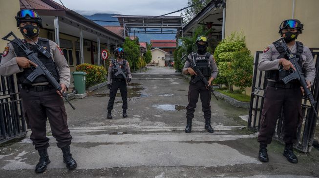 Polisi berjaga di depan gerbang Rumah Sakit Bhayangkara yang akan menjadi lokasi identifikasi dua jenazah dari kelompok DPO Mujahidin Indonesia Timur (MIT) Poso di Palu, Sulawesi Tengah, Minggu (11/7/2021). [ANTARA FOTO/Basri Marzuki]