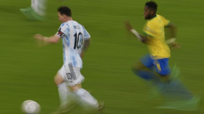 Pemain Argentina Lionel Messi (kiri) dan pemain Brasil Fred berebut bola dalam pertandingan final turnamen sepak bola Copa America Conmebol 2021 di Stadion Maracana, Rio de Janeiro, Brasil, pada (10/7/2021). [MAURO PIMENTEL / AFP]