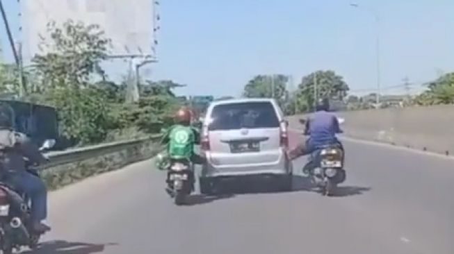 Aksi 2 Pemotor Tunjukkan Kekuatan Super, Dorong Mobil Bermodalkan Sebelah Kaki Saja