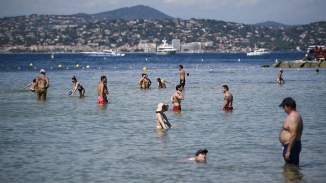 Orang-orang mengunjungi pantai La Bouillabaisse setelah Prancis baru-baru ini melonggarkan tindakan pencegahan penyebaran COVID-19 di Ramatuelle, Saint-Tropez, Prancis, pada (10/7/2021). [CLEMENT MAHOUDEAU / AFP]