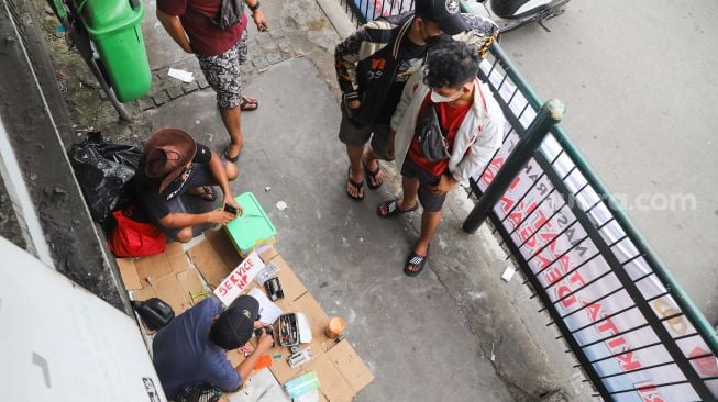 Penyedia jasa servis mereparasi handphone di  Kawasan Pusat Grosir Cililitan (PGC), Jakarta Timur, Selasa (13/7/2021). [Suara.com/Alfian Winanto]