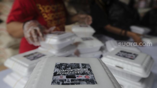 Sukarelawan menyiapkan makanan di dapur umum peduli COVID-19 di Karet Semanggi, Setiabudi, Jakarta, Selasa (13/7/2021). [Suara.com/Angga Budhiyanto]