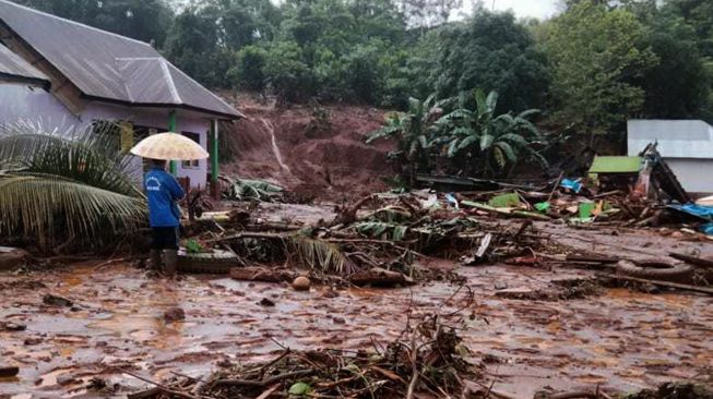 Warga berada dibangunan rumah yang rusak akibat banjir bandang di Kecamatan Molawe, Konawe Utara, Sulawesi Tenggara, Senin (12/7/2021). ANTARA FOTO/Suyamin
