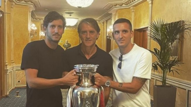 Andrea Mancini (kanan) bersama sang ayah Roberto Mancini (tengah) berfoto dengan trofi Euro 2020 yang dimenangkan Italia usai mengalahkan Inggris dalam laga final di Stadion Wembley, London, Senin (11/7/2021). [Instagram @manciojr_]