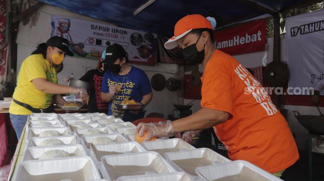 Sukarelawan menyiapkan makanan di dapur umum peduli COVID-19 di Karet Semanggi, Setiabudi, Jakarta, Selasa (13/7/2021). [Suara.com/Angga Budhiyanto]