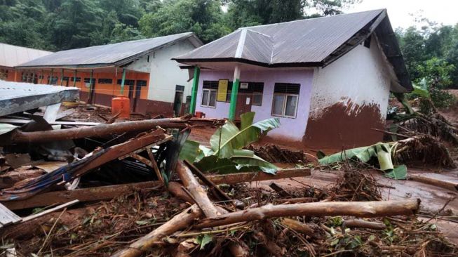 Kondisi di halaman SD Negeri 07 Molawe tertutup material banjir bandang di Kecamatan Molawe, Konawe Utara, Sulawesi Tenggara, Senin (12/7/2021). ANTARA FOTO/Suyamin
