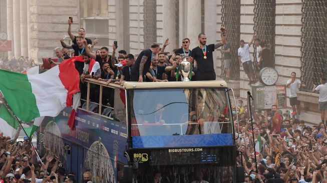 Para pemain Italia berada di atas bus saat perayaan juara Euro 2020 di Roma, Senin (12/7).  [AFP]
