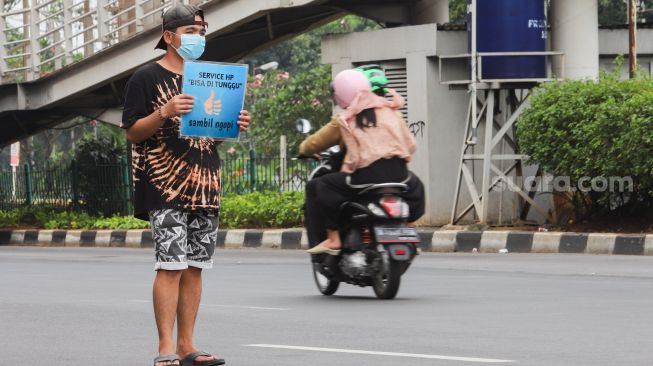 Penyedia jasa servis handphone menawarkan jasanya di Kawasan Pusat Grosir Cililitan (PGC), Jakarta Timur, Selasa (13/7/2021). [Suara.com/Alfian Winanto]