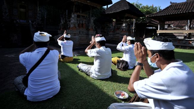 Umat Hindu mengikuti ritual upacara Ngrastiti Bhakti di kawasan Kuta, Badung, Bali, Rabu (14/7/2021).  ANTARA FOTO/Fikri Yusuf
