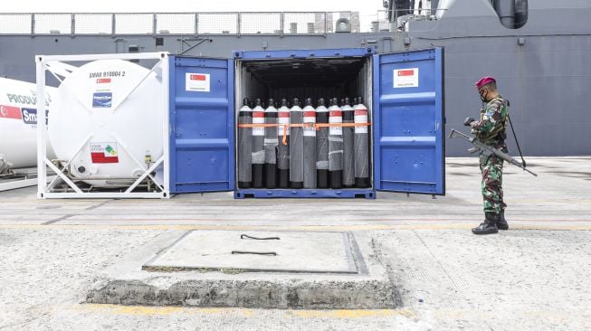 Prajurit Korps Marinir TNI AL berdiri di depan iso tank yang baru diturunkan dari kapal perang Singapura, RSS Endeavour-210 di Pelabuhan Tanjung Priok, Jakarta, Rabu (14/7/2021).  ANTARA FOTO