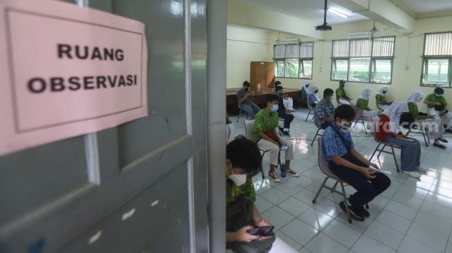 Para pelajar saat menjalani proses observasi usai menjalani vaksinasi Covid-19 di SMA Negeri 38, Jakarta Selatan, Kamis (15/7/2021). [Suara.com/Alfian Winanto]