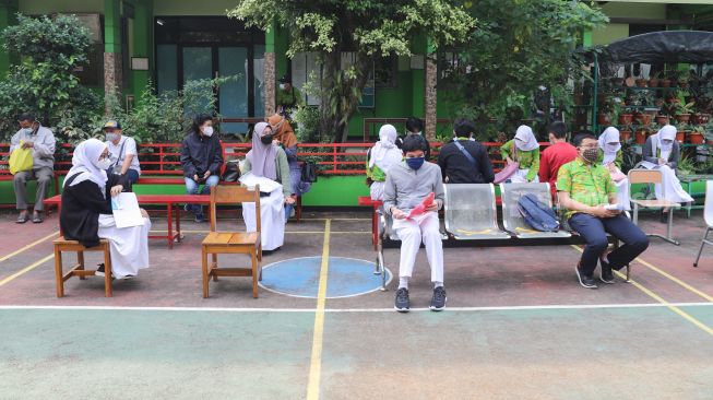 Para pelajar menunggu giliran untuk menjalani vaksinasi Covid-19 di SMA Negeri 38, Jakarta Selatan, Kamis (15/7/2021). [Suara.com/Alfian Winanto]