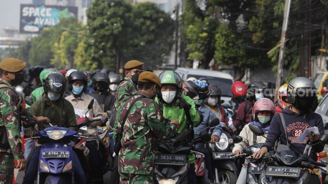 Personel TNI memeriksa kelengkapan surat tanda registrasi pekerja (STRP) di pos penyekatan PPKM Darurat Underpass Mampang, Jakarta, Kamis (15/7/2021). [Suara.com/Angga Budhiyanto]