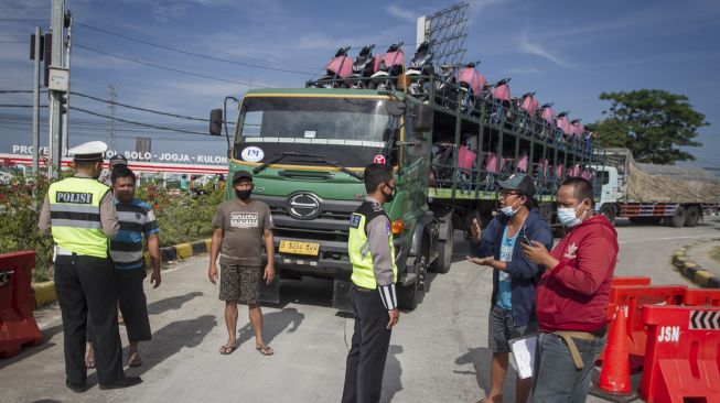 Polisi memeriksa dokumen perjalanan sopir truk yang akan masuk tol melalui Gerbang Tol Colomadu di Karanganyar, Jawa Tengah, Jumat (16/7/2021). [ANTARA FOTO/Mohammad Ayudha]