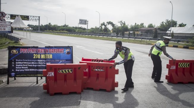 Polisi memasang barier saat melakukan penyekatan kendaraan yang akan masuk tol melalui Gerbang Tol Colomadu di Karanganyar, Jawa Tengah, Jumat (16/7/2021). [ANTARA FOTO/Mohammad Ayudha]