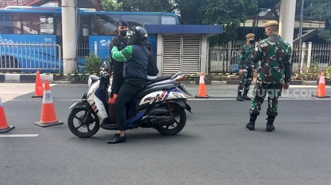 Sopir driver ojol saat diperiksa aparat gabungan di pos penyekatan di Mampang Prapanca Raya, Jaksel. (Suara.com/Arga)