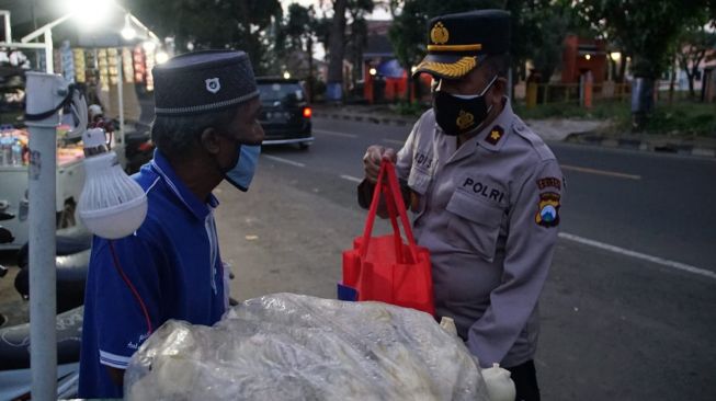 Polisi dari Polres Malang memberikan bantuan sembako kepada para pedagang di wilayah wilayah Kepanjen dan Stadion Kanjuruhan. [dokumentasi pribadi]