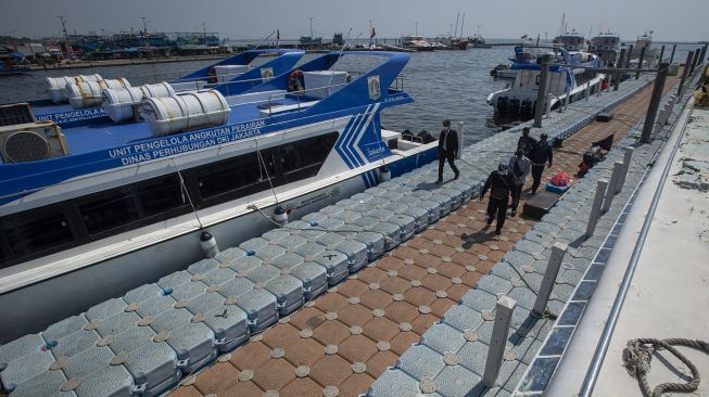 Sejumlah petugas berjalan di dermaga Pelabuhan Kaliadem, Muara Angke, Jakarta, Sabtu (17/7/2021). [ANTARA FOTO/Aditya Pradana Putra]