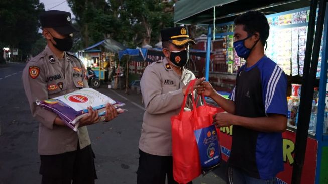 Polisi dari Polres Malang memberikan bantuan sembako kepada para pedagang. [dokumentasi pribadi]