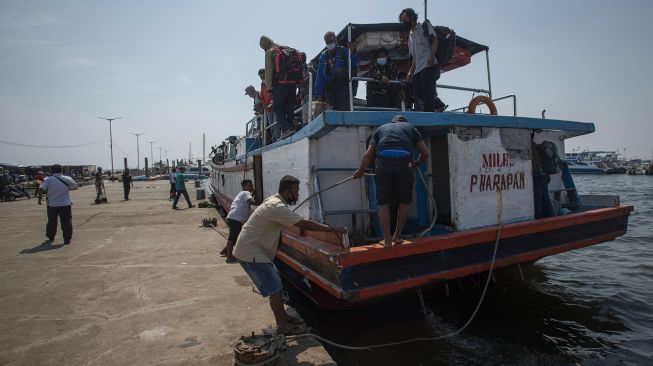 Petugas menarik kapal pengangkut penumpang untuk bersandar di dermaga Pelabuhan Kaliadem, Muara Angke, Jakarta, Sabtu (17/7/2021). [ANTARA FOTO/Aditya Pradana Putra]