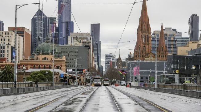 Jalan St Kilda yang biasanya sibuk terlihat sepi dari lalu lintas padat di Melbourne, Australia, pada (16/7/2021). [ASANKA BRENDON RATNAYAKE / AFP]