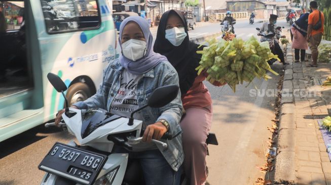 Warga membeli kulit ketupat  di Pasar Palmerah, Jakarta Pusat, Minggu (18/7/2021). [Suara.com/Alfian Winanto]