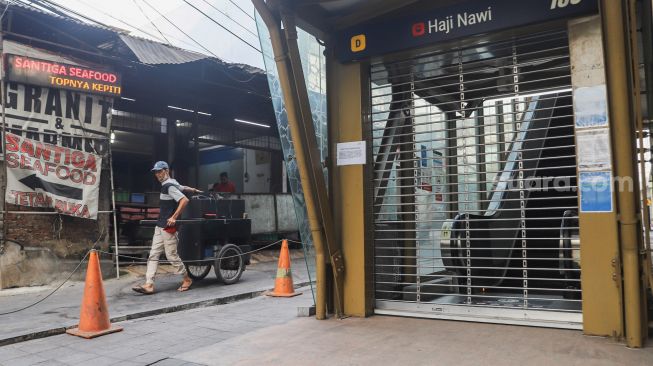 Warga melintas di Stasiun MRT Haji Nawi, Jakarta Selatan, Minggu (18/7/2021). [Suara.com/Alfian Winanto]