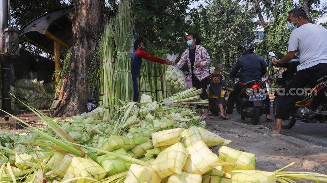 Warga membeli kulit ketupat  di Pasar Palmerah, Jakarta Pusat, Minggu (18/7/2021). [Suara.com/Alfian Winanto]