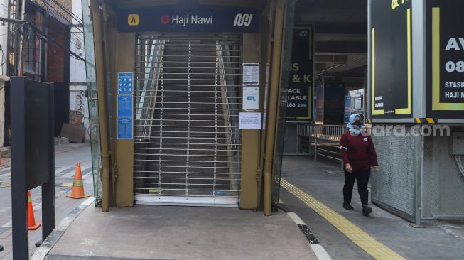 Warga melintas di Stasiun MRT Haji Nawi, Jakarta Selatan, Minggu (18/7/2021). [Suara.com/Alfian Winanto]