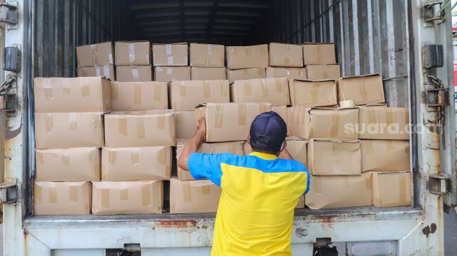 Petugas menaruh paket bantuan ke dalam truk di Lapangan Monumen Nasional (Monas), Jakarta Pusat, Senin (19/7/2021). [Suara.com/Alfian Winanto]