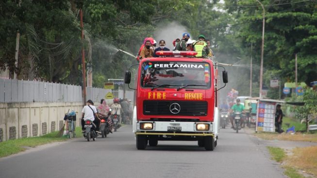 Prajurit Yonif 8 Marinir melakukan penyemprotan disinfektan guna mencegah penyebaran Covid-19. [Ist]