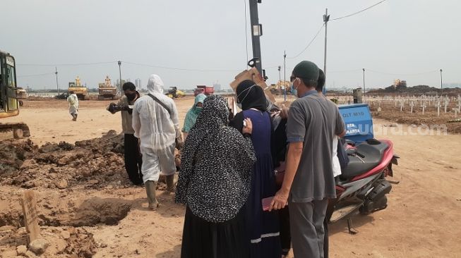 Banyak keluarga antar jenazah pasien Covid-19 hingga ke petak makam di TPU Rorotan, Jakarta Utara. (Suara.com/Yaumal)