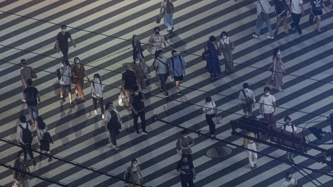 Sejumlah warga menyeberang jalan di kota Shinjuku, Tokyo, Jepang, Minggu (18/7/2021).  ANTARA FOTO/Sigid Kurniawan