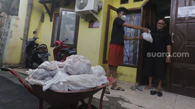 Warga membagikan daging kurban dari rumah ke rumah atau 'door to door' di kawasan Jati Padang Utara, Pasar Minggu, Jakarta, Selasa (20/7/2021). [Suara.com/Angga Budhiyanto]