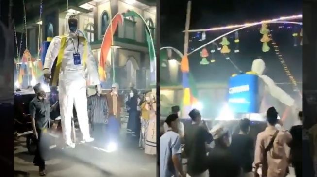 Unik! Sambil Takbiran, Warga Bawa Boneka Raksasa Ber-APD Semprot Disinfektan ke Jalan