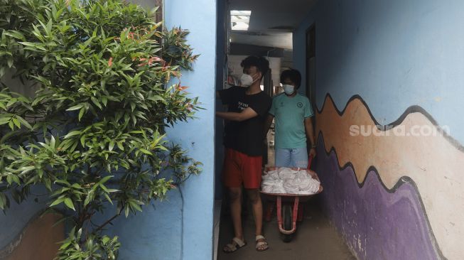 Warga membagikan daging kurban dari rumah ke rumah atau 'door to door' di kawasan Jati Padang Utara, Pasar Minggu, Jakarta, Selasa (20/7/2021). [Suara.com/Angga Budhiyanto]