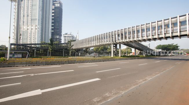 Suasanan Lengangnya kawasan Sudirman, Jakarta Pusat, Selasa (20/7/2021). [Suara.com/Alfian Winanto]