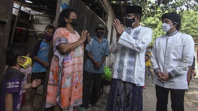 Menteri Pariwisata dan Ekonomi Kreatif (Manparekraf) Sandiaga Uno (kedua kanan) bersama Youtuber Atta Halilintar (kanan) membagikan daging kurban di kawasan Rumah Pemotongan Hewan, Juanda, Depok, Jawa Barat, Selasa (20/7/2021).  ANTARA FOTO/Asprilla Dwi Adha