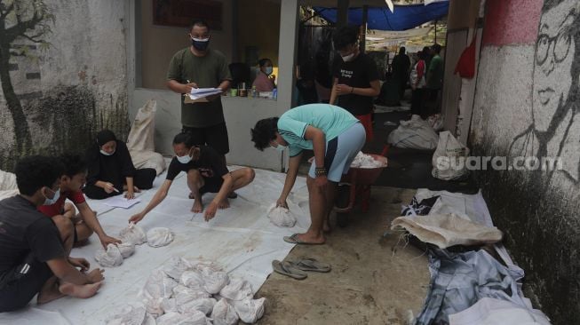 Warga bersiap membagikan daging kurban dari rumah ke rumah atau 'door to door' di kawasan Jati Padang Utara, Pasar Minggu, Jakarta, Selasa (20/7/2021). [Suara.com/Angga Budhiyanto]