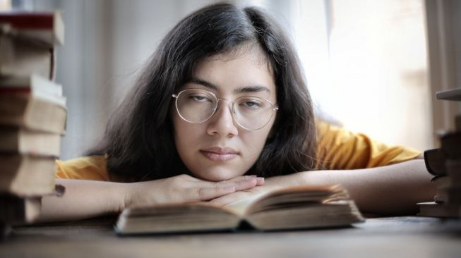 Ilustrasi perempuan reading slump. (pexels.com/Andrea Piacquadio)