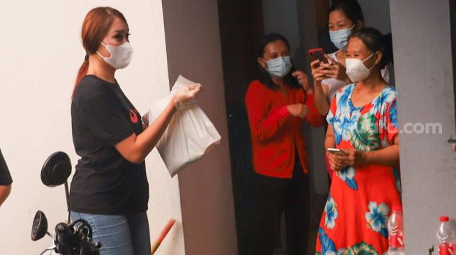 Lucinta Luna membagikan paket bantuan berupa daging kurban dan sembako kepada warga di sekitar rumah Pedangdut Dewi Perssik di Kawasan Fatmawati, Jakarta Selatan, Selasa (20/7/2021). [Suara.com/Alfian Winanto]