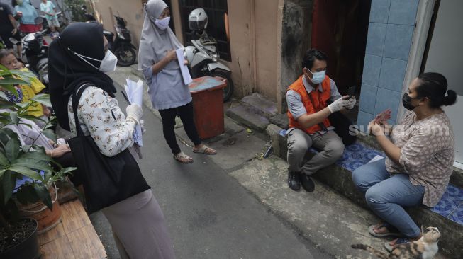 Petugas Pos menyalurkan Bantuan Sosial Tunai (BST) dari rumah ke rumah di kawasan Petojo Selatan, Gambir, Jakarta, Rabu (21/7/2021). [Suara.com/Angga Budhiyanto]