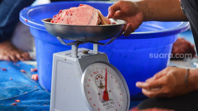 Petugas menimbang daging hewan kurban untuk proses pembagian di Masjid Agung Al Azhar, Jakarta Selatan, Rabu (21/7/2021). [Suara.com/Alfian Winanto]