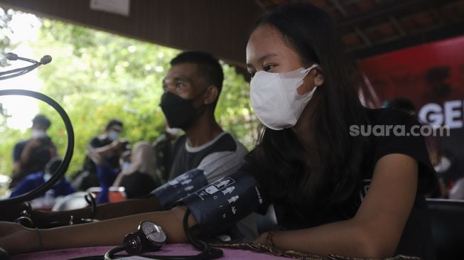 Tenaga kesehatan memeriksa kondisi kesehatan warga yang akan mendapatkan vaksin COVID-19 di Rusun Petamburan, Tanah Abang, Jakarta, Kamis (22/7/2021). [Suara.com/Angga Budhiyanto]