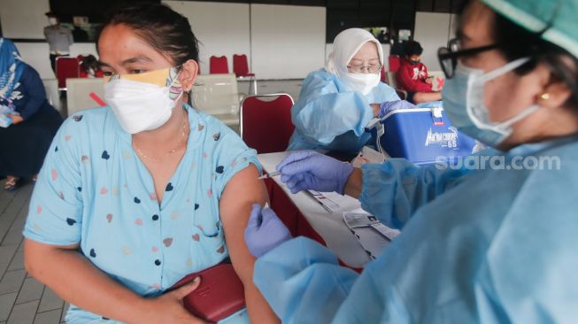 Warga menjalani proses vaksinasi covid-19 di Terminal Kampung Rambutan, Jakarta Timur, Kamis (22/7/2021). [Suara.com/Alfian Winanto]