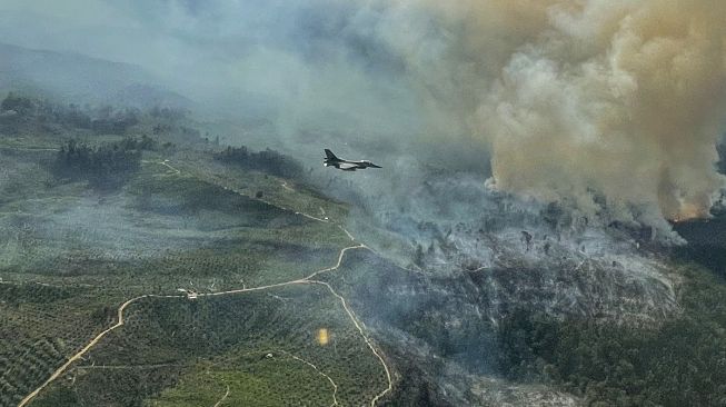 Pesawat tempur F-16 dari Skadron Udara 16/Rydder Lanud Roesmin Pekanbaru, terbang diatas lahan yang terbakar di Koto Tuo, Kampar, Riau, Rabu (21/7/2021). [Antara/Skadron Udara 16/Rydder Lanud Roesmin Nurjadin Pekanbaru/Lettu Pnb Tommy Yulianto]