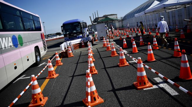 Peserta Olimpiade Tokyo 2020 antre menaiki bus di Media Transport Mall, Tokyo, Jepang, Rabu (21/7/2021).  ANTARA FOTO/Sigid Kurniawan