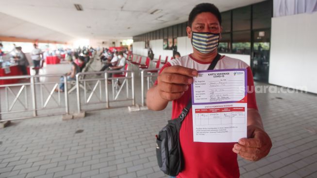 Warga menunjukkan sertifikat vaksin usai menjalani vaksinasi covid-19 di Terminal Kampung Rambutan, Jakarta Timur, Kamis (22/7/2021). [Suara.com/Alfian Winanto]