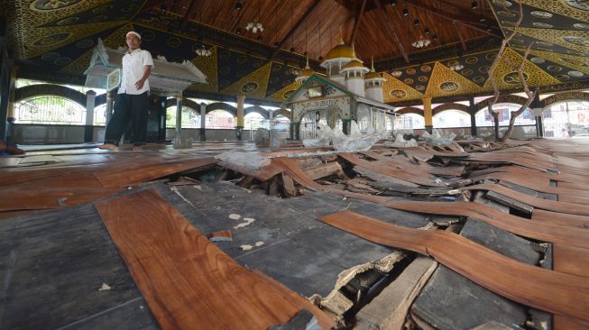 Warga berjalan di atas lantai rusak di Komplek Makam Syekh Burhanuddin, Ulakan, Padangpariaman, Sumatera Barat, Kamis (22/7/2021). ANTARA FOTO/Iggoy el Fitra