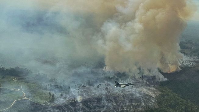 Pesawat tempur F-16 dari Skadron Udara 16/Rydder Lanud Roesmin Pekanbaru, terbang diatas lahan yang terbakar di Koto Tuo, Kampar, Riau, Rabu (21/7/2021). [Antara/Skadron Udara 16/Rydder Lanud Roesmin Nurjadin Pekanbaru/Lettu Pnb Tommy Yulianto]